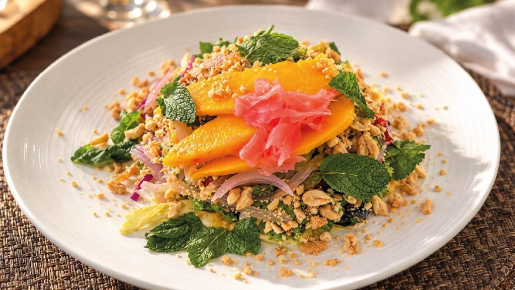 Thai Mango Salad — Dominican Thai. Nota: La composición de esta imagen fue mejorada con inteligencia artificial. El plato se mantiene intacto respecto a la fotografía original.